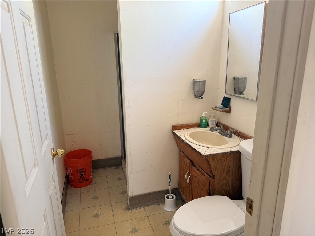 1391 West Dyer Road Pahrump, NV 89048 - Photo 29 of 50 A well-lit bathroom with functional tile flooring and a classic vanity.