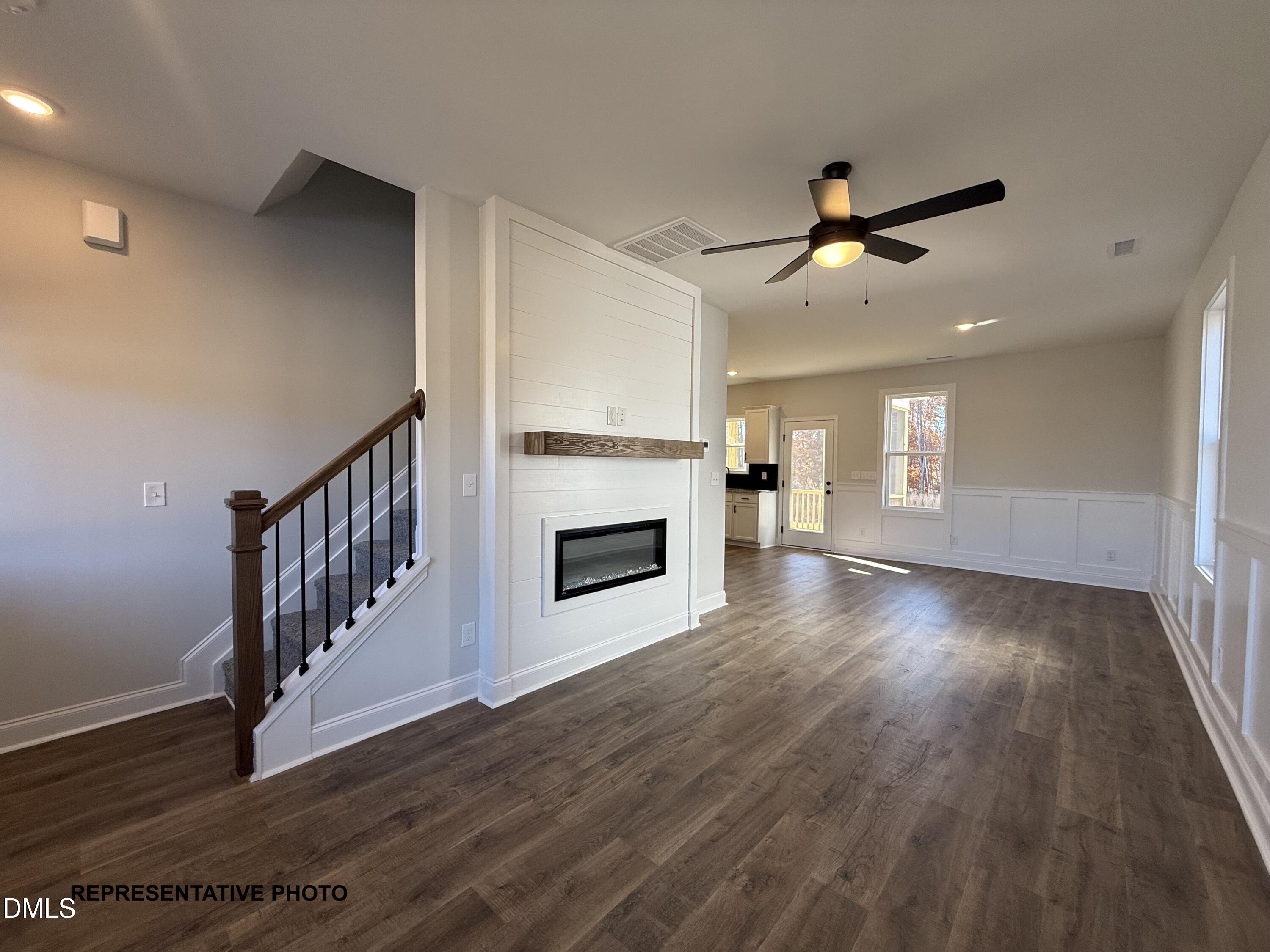 308 Bluejay Street Clayton, NC 27520 - Photo 4 of 14 a view of a livingroom with wooden floor a ceiling fan and kitchen space