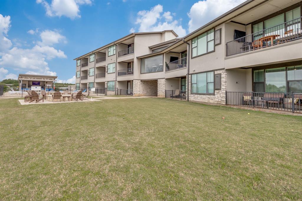 3412 Scenic Point Road, Unit 102 Graford, TX 76449 - Photo 28 of 31 a view of a building with a large window and lawn chairs