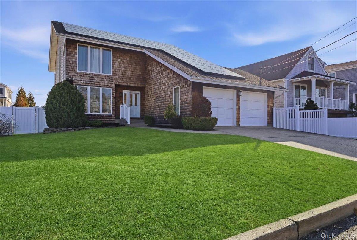 a brick house with a big yard and large trees