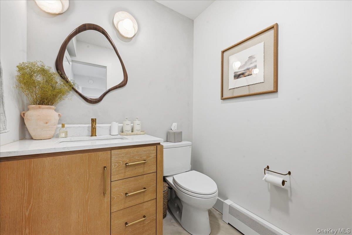 141 Annuskemunnica Road Babylon, NY 11702 - Photo 16 of 44 a bathroom with a toilet a sink and a mirror