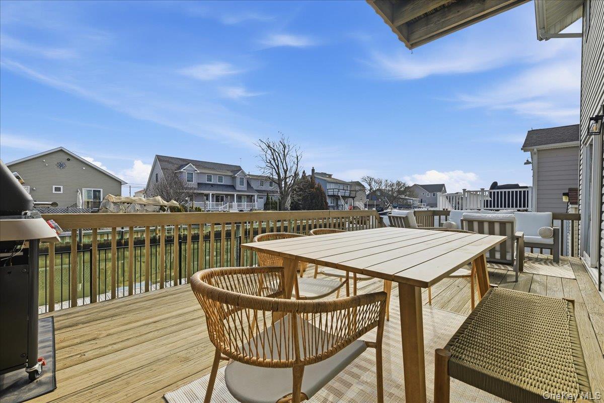 141 Annuskemunnica Road Babylon, NY 11702 - Photo 31 of 44 a view of a rooftop deck with chairs and wooden floor