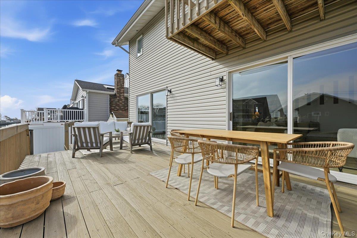 141 Annuskemunnica Road Babylon, NY 11702 - Photo 32 of 44 a view of a roof deck with table and chairs couches and potted plants