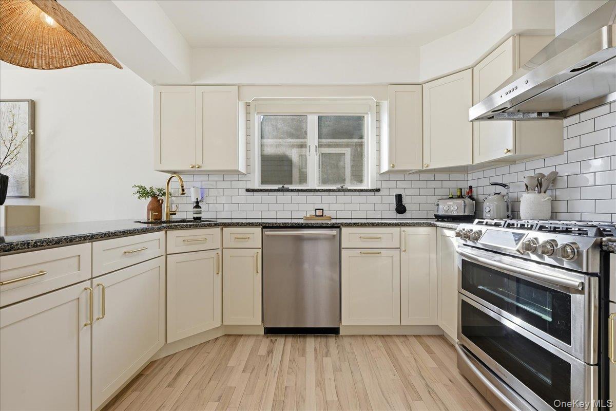 141 Annuskemunnica Road Babylon, NY 11702 - Photo 8 of 44 a kitchen with granite countertop a stove sink and cabinets