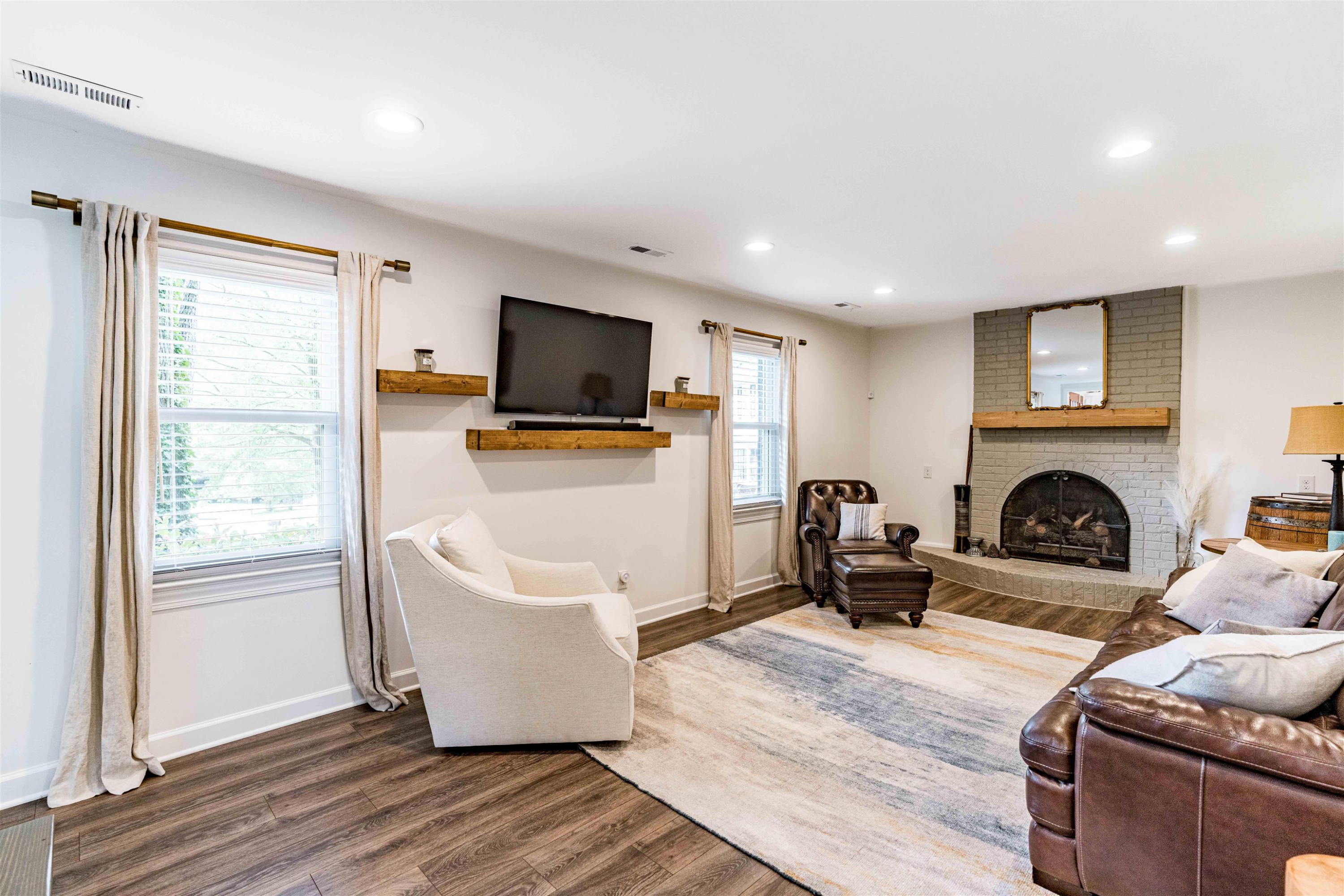 1505 Windbur Place Raleigh, NC 27609 - Photo 30 of 44 a living room with furniture a flat screen tv and a fireplace