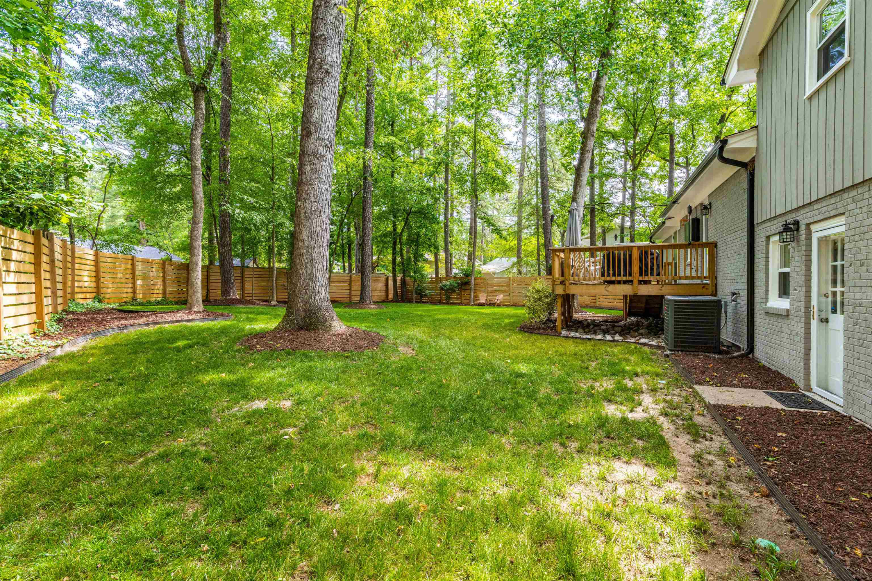 1505 Windbur Place Raleigh, NC 27609 - Photo 41 of 44 a view of a backyard with large trees and wooden fence