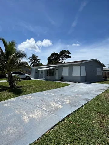 a front view of a house with a garden and yard