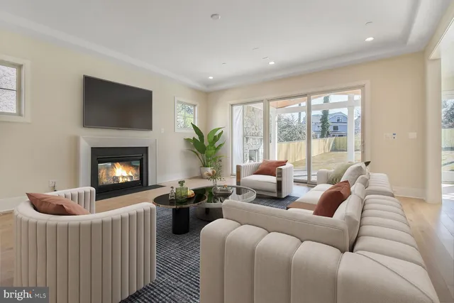 a living room with furniture a large window and a fireplace