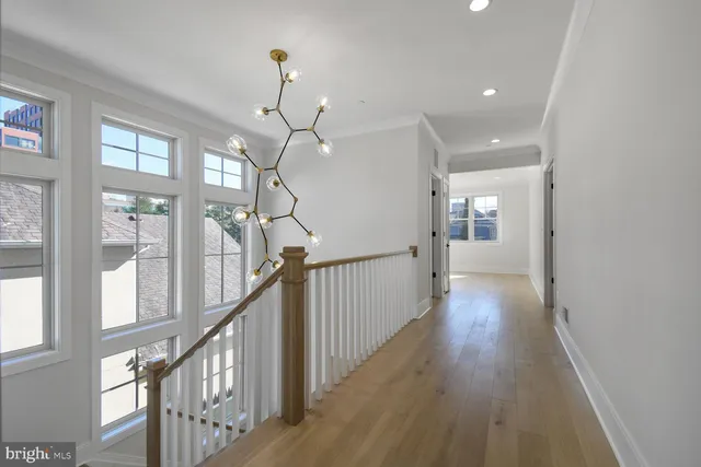 a view of a hallway with wooden floor and staircase