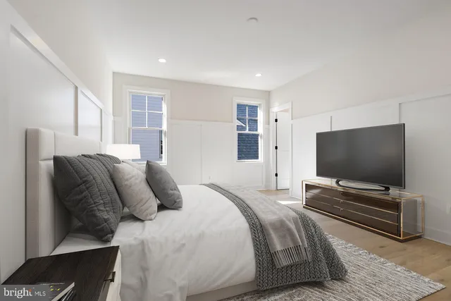 a bedroom with bed and flat screen tv