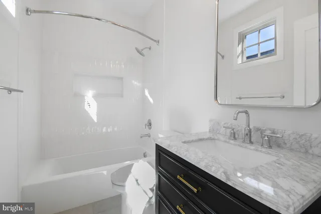 a bathroom with a granite countertop bathtub sink vanity and mirror