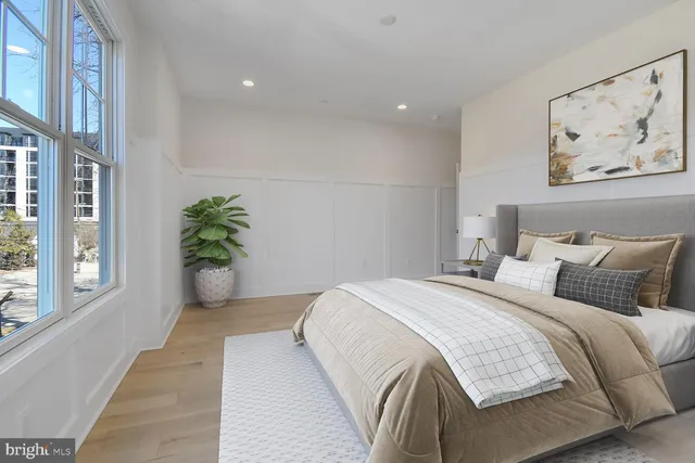 a bedroom with a bed and a painting on the wall