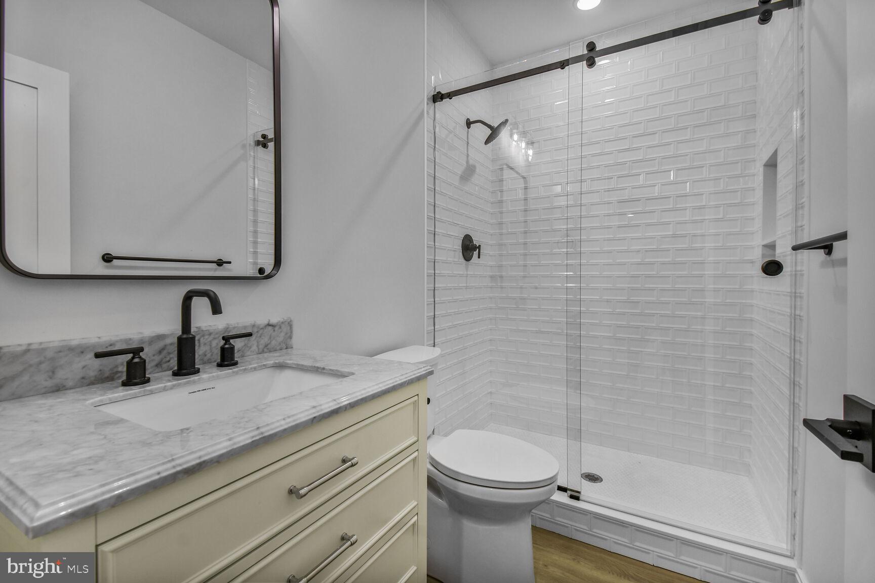 7819 Exeter Road Bethesda, MD 20814 - Photo 41 of 44 a bathroom with a granite countertop sink toilet and shower