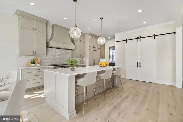 a large kitchen with a sink stainless steel appliances and cabinets