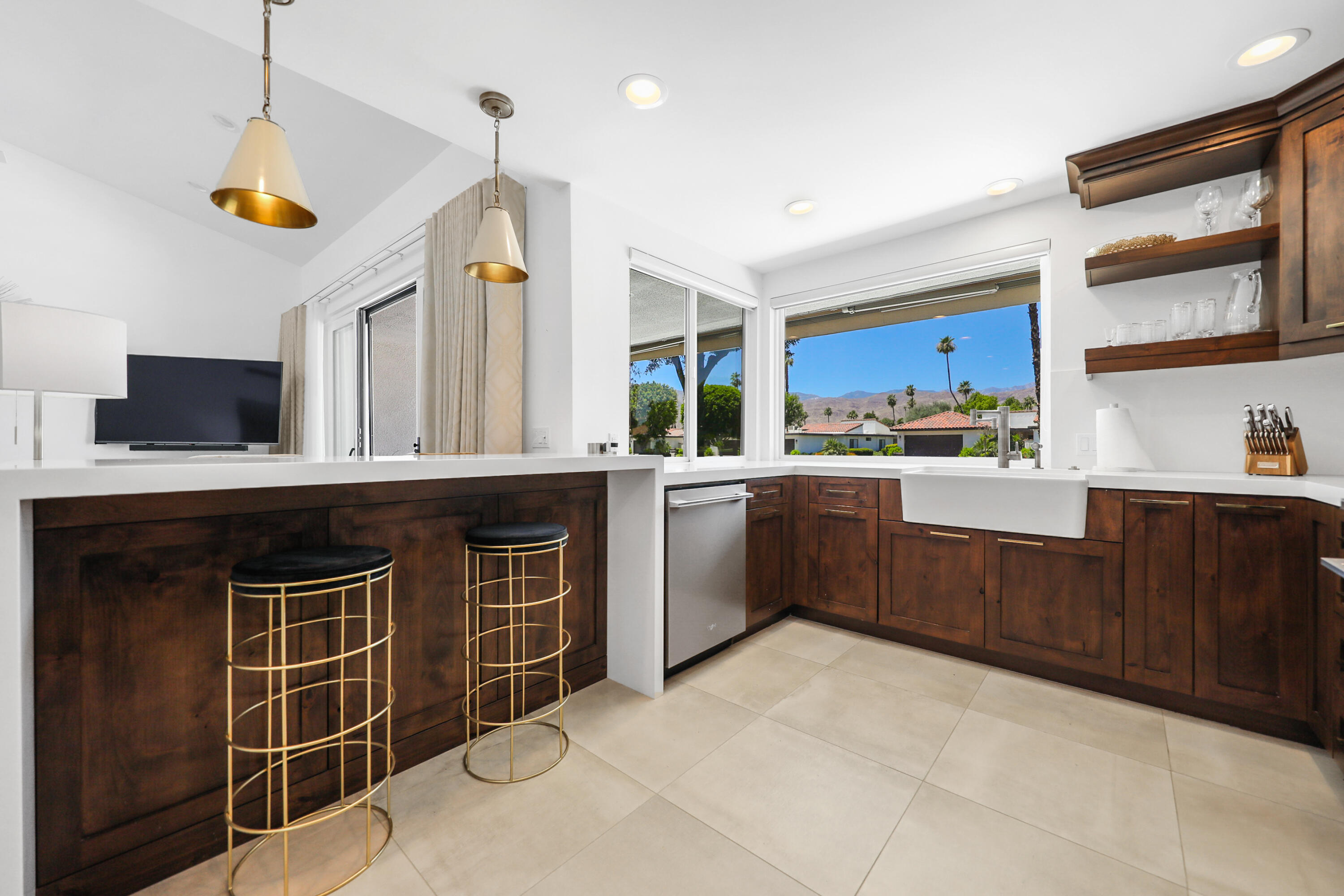 24 Leon Way Rancho Mirage, CA 92270 - Photo 8 of 30 a kitchen with a sink window and wooden cabinets