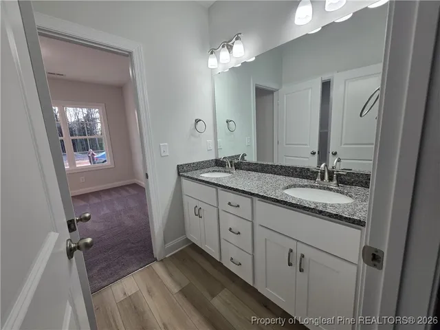 a spacious bathroom with a granite countertop sink a mirror and a shower