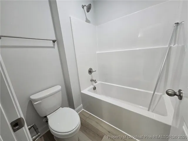 a white toilet sitting next to a bath tub