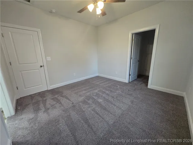 a view of an empty room and a chandelier fan