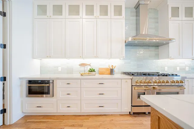 a kitchen with stainless steel appliances granite countertop a stove a sink and a microwave