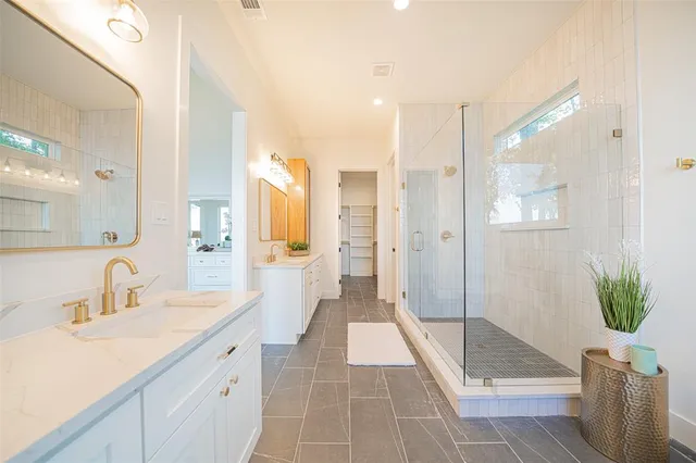 a bathroom with a double vanity sink and shower