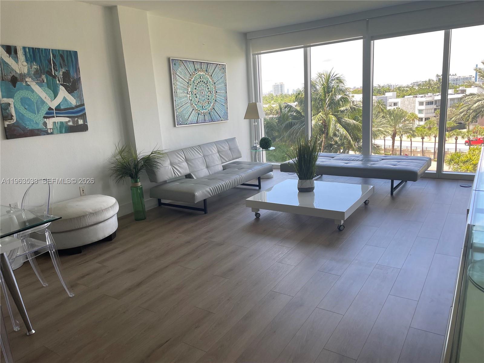 10275 Collins Avenue, Unit 427 Bal Harbour, FL 33154 - Photo 4 of 21 a living room with furniture and a large window