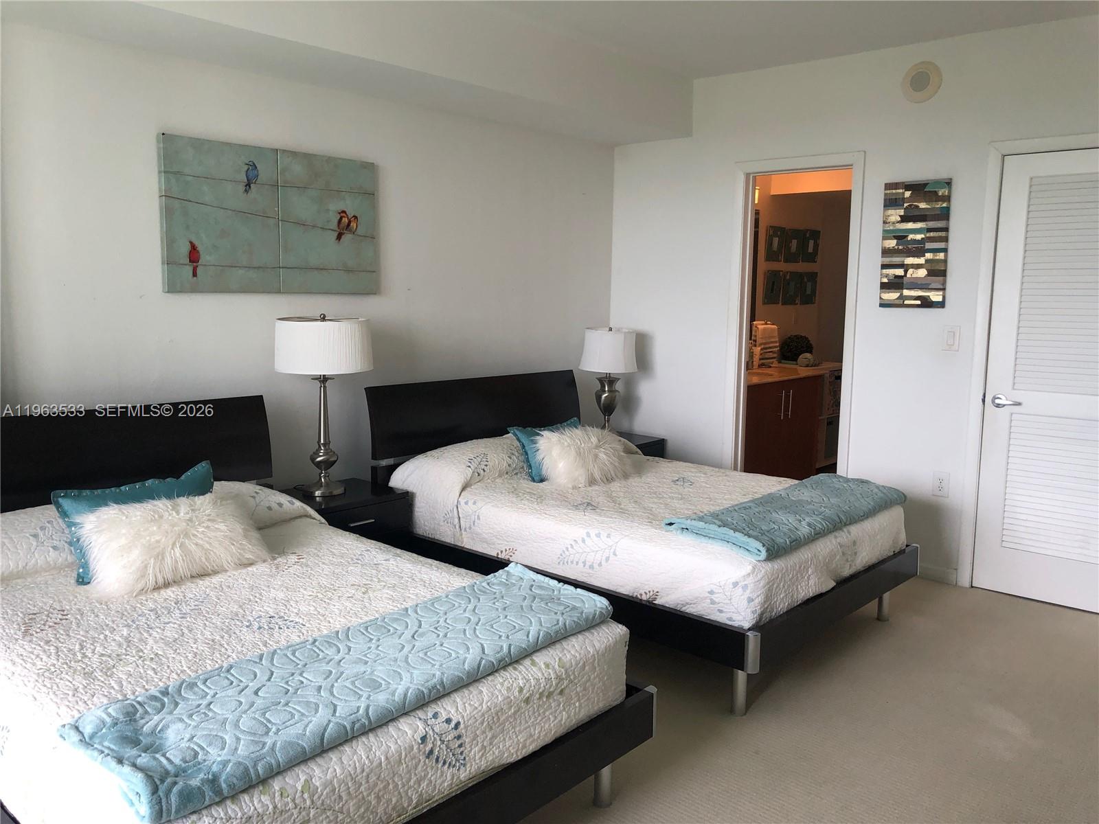 10275 Collins Avenue, Unit 427 Bal Harbour, FL 33154 - Photo 6 of 21 a bedroom with two beds and painting on the wall