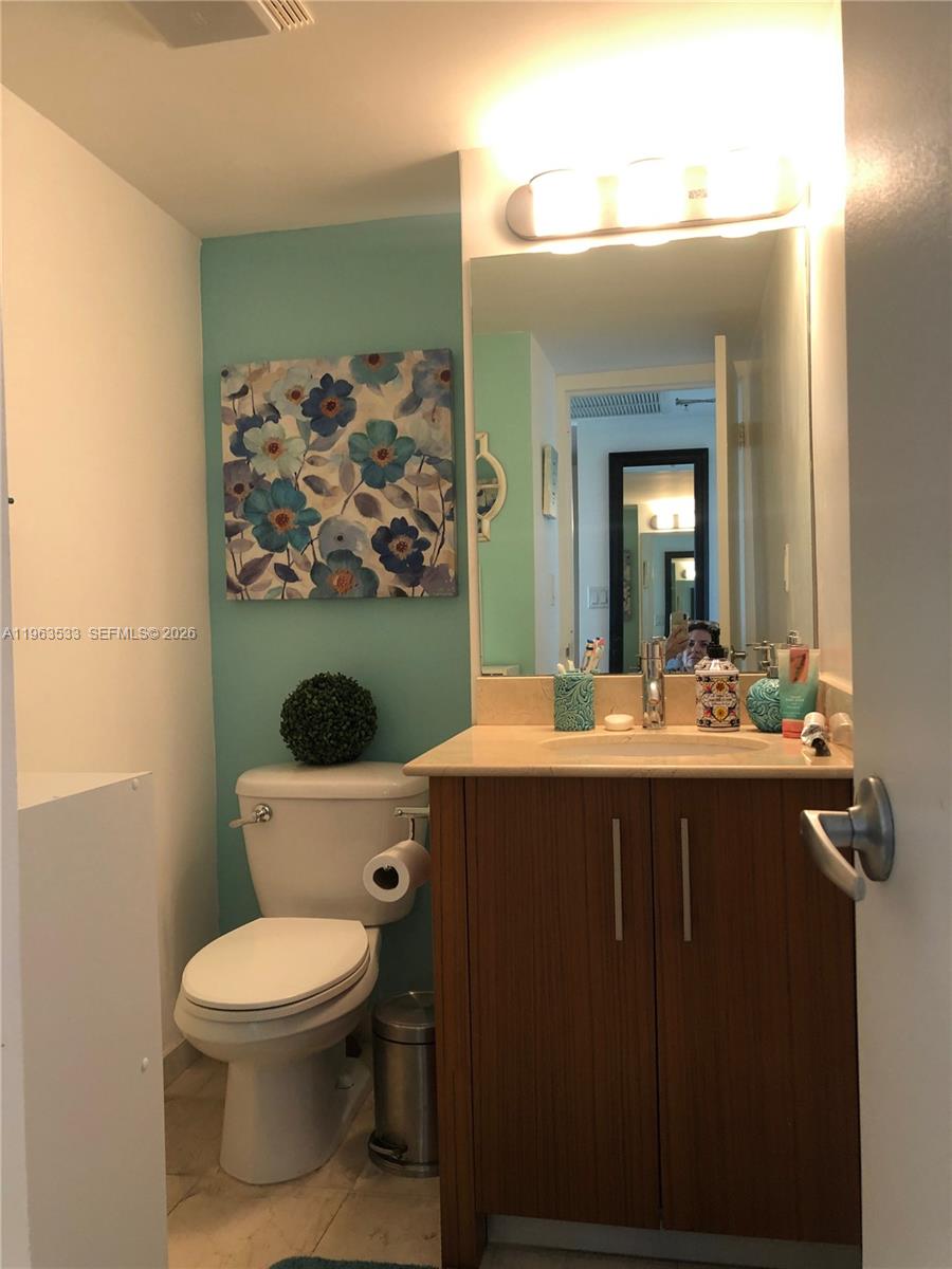 10275 Collins Avenue, Unit 427 Bal Harbour, FL 33154 - Photo 8 of 21 a bathroom with a toilet a sink and mirror