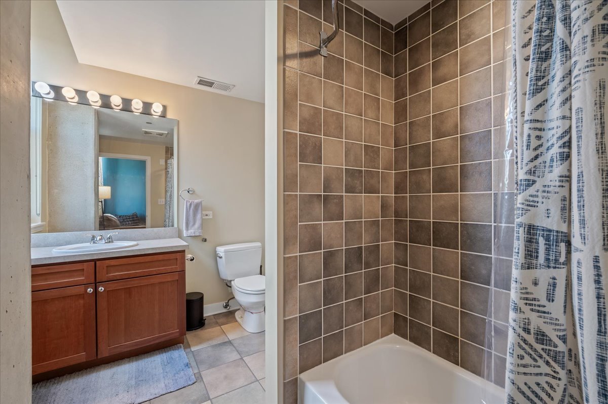 811 West 15th Place, Unit 708 Chicago, IL 60608 - Photo 18 of 26 a bathroom with a toilet a sink and mirror