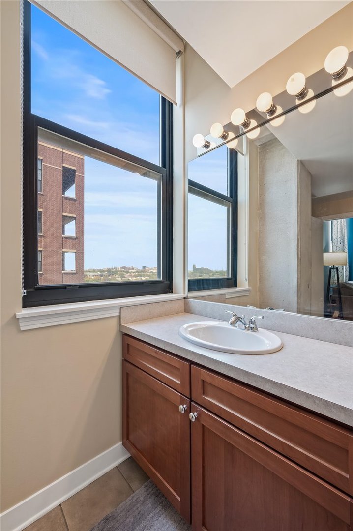 811 West 15th Place, Unit 708 Chicago, IL 60608 - Photo 19 of 26 a bathroom with a granite countertop sink and a mirror
