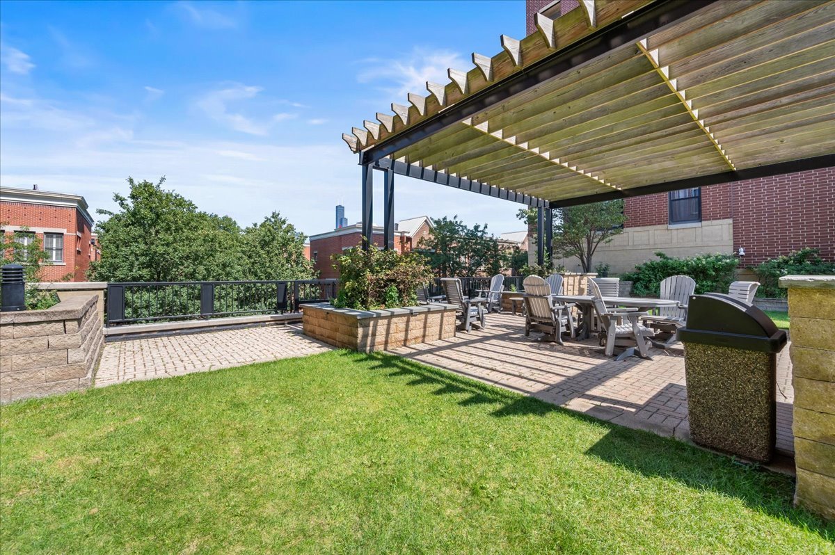 811 West 15th Place, Unit 708 Chicago, IL 60608 - Photo 22 of 26 a view of a patio with table and chairs potted plants with palm trees