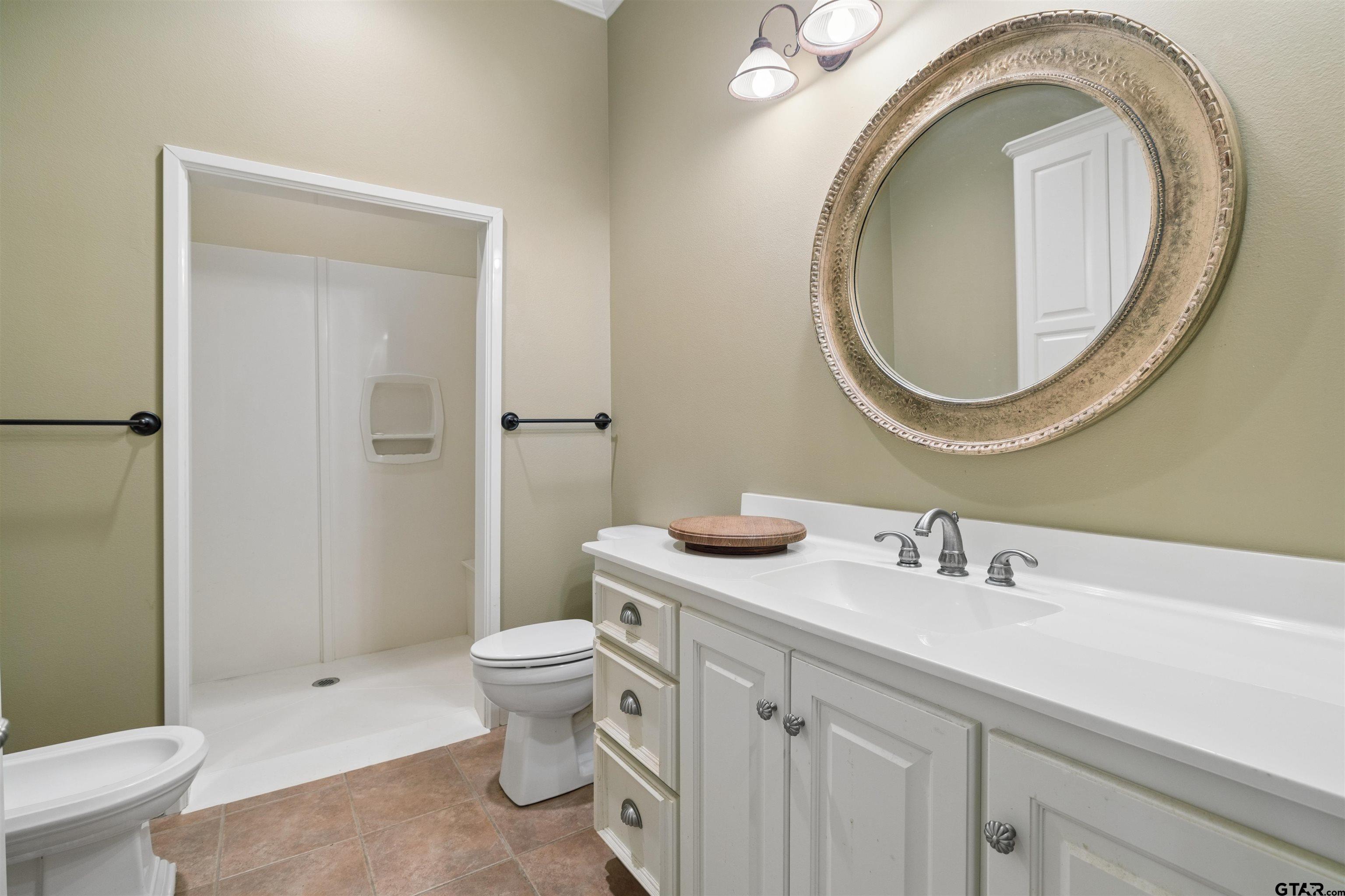 15120 Big Oak Bay Road Tyler, TX 75707 - Photo 19 of 34 a bathroom with a toilet a sink and a mirror