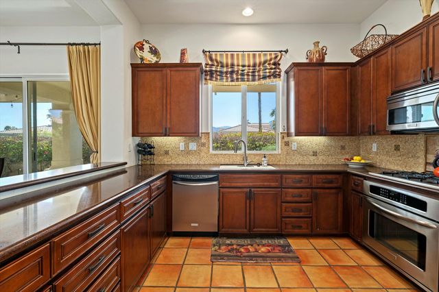 a kitchen with stainless steel appliances a sink stove and cabinets