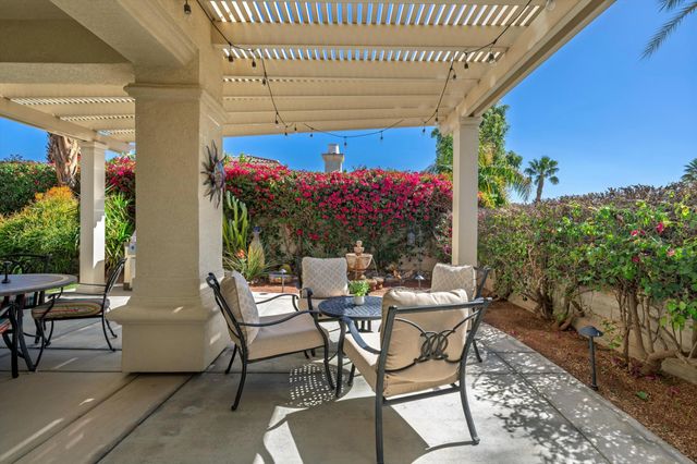 a view of a patio with a table and chairs and potted plants