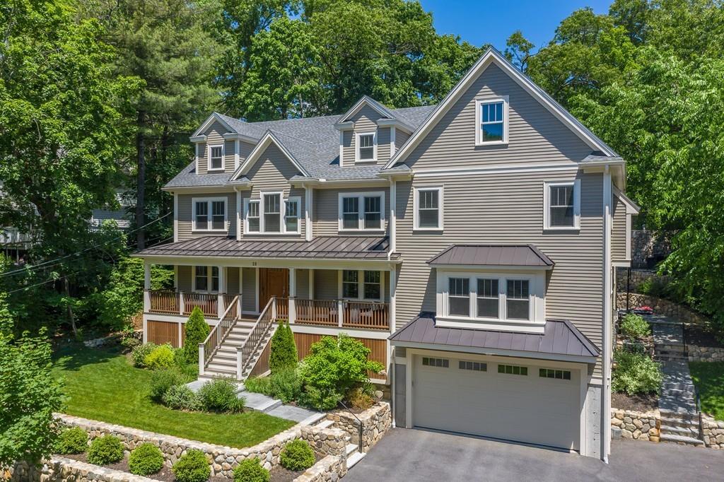 a front view of a house with a yard and potted plants