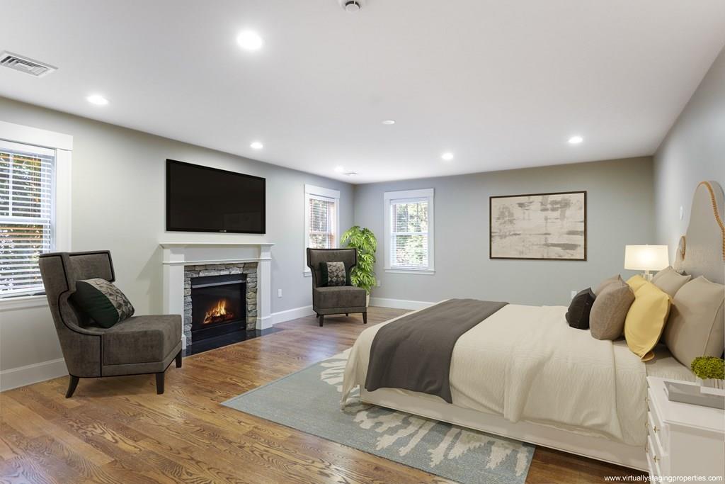 28 Fells Road Winchester, MA 01890 - Photo 21 of 42 a spacious bedroom with a bed a couch and a flat screen tv