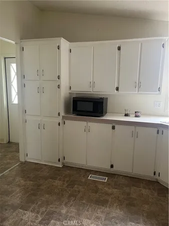 a kitchen with granite countertop white cabinets and white appliances