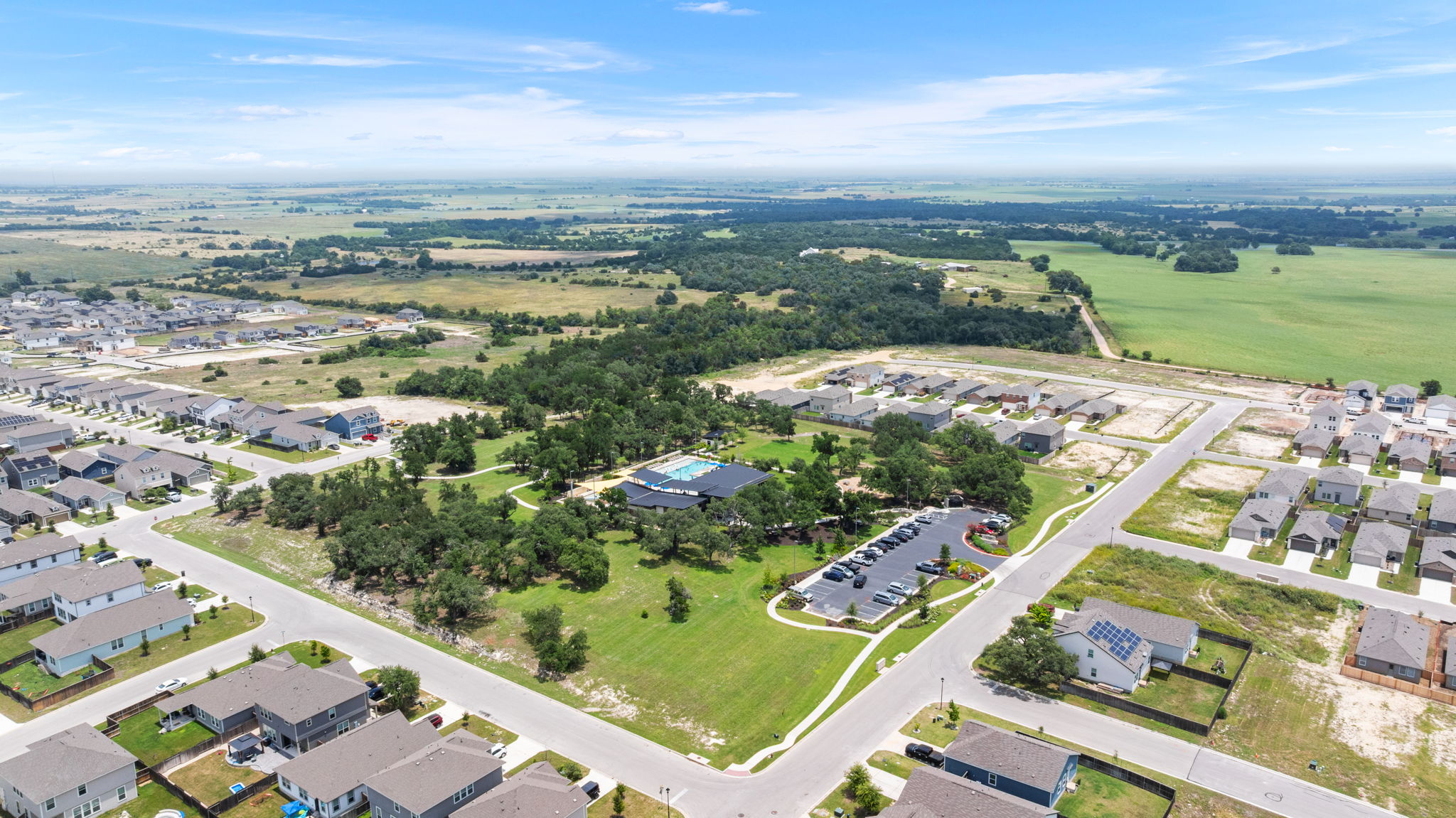 313 Mclintock Road Jarrell, TX 76537 - Photo 35 of 40 An aerial perspective reveals a serene residential community with a welcoming pool and vast natural surroundings.