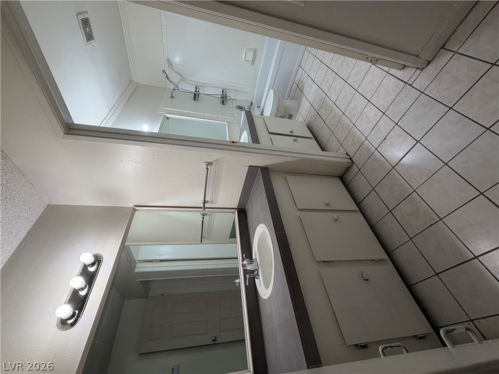 2236 East Desert Inn Road Las Vegas, NV 89169 - Photo 21 of 31 Functional bathroom featuring a shower, toilet, and vanity with built-in storage.
