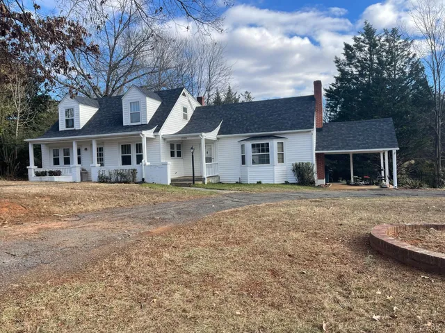 a front view of a house with a yard and potted plants