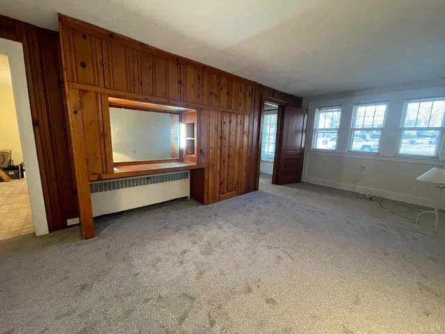 an empty room with wooden floor and cabinet