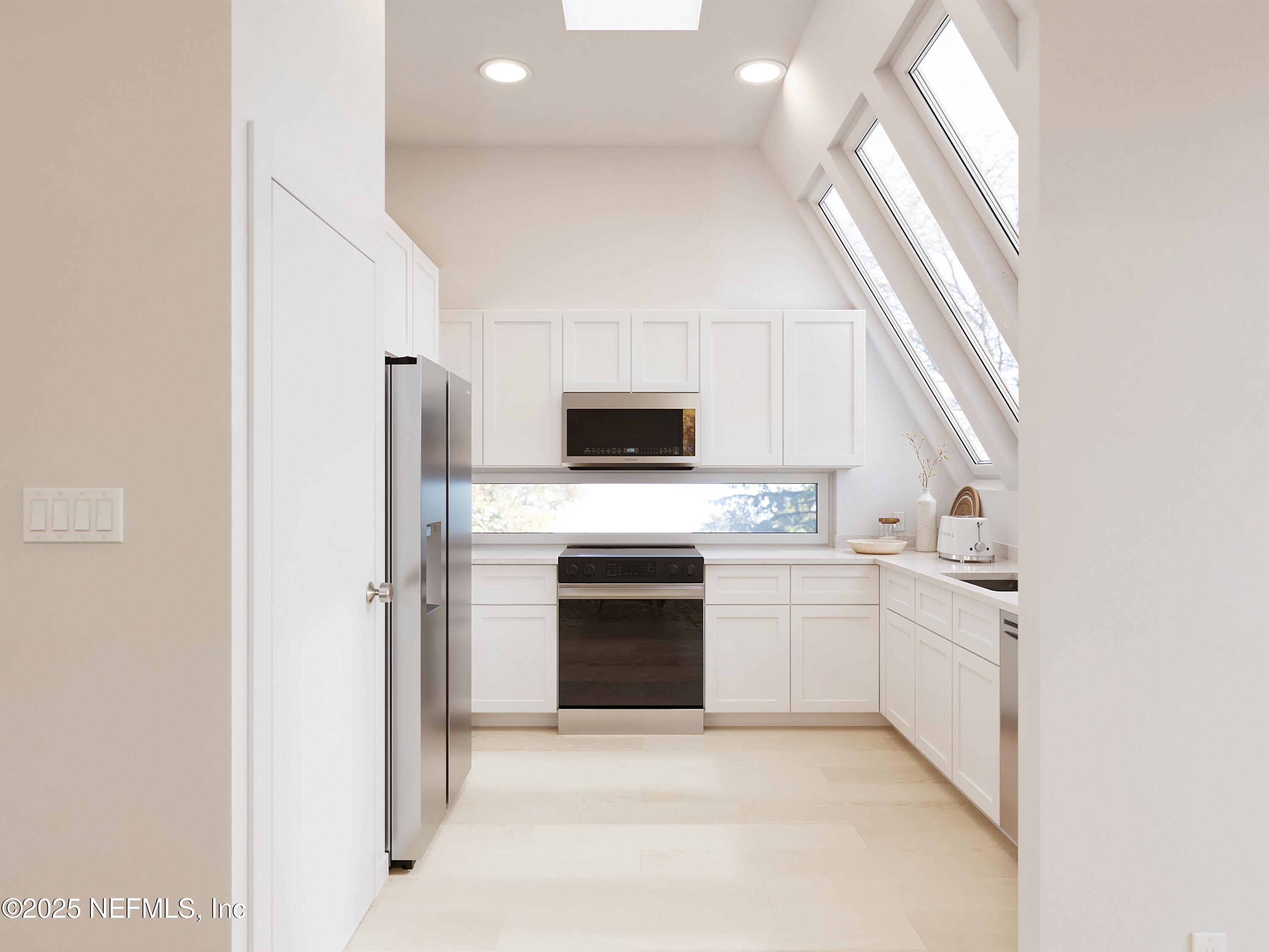 22 Poinciana Cove Road St. Augustine, FL 32084 - Photo 7 of 20 a kitchen with white cabinets and stainless steel appliances