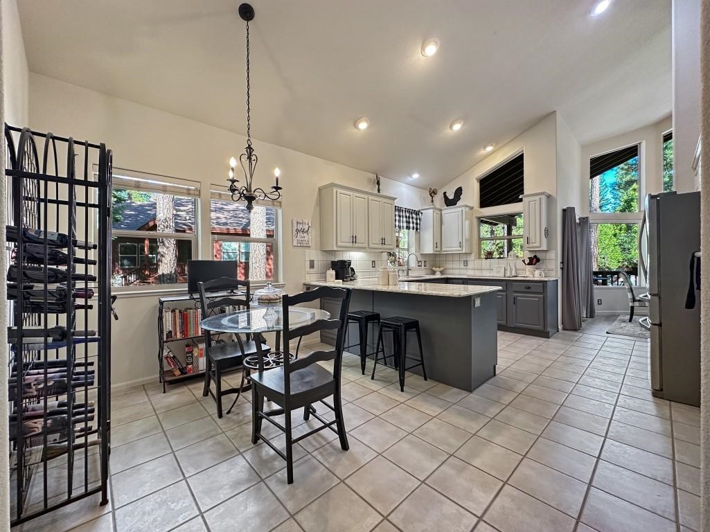 27 One Horse Way Clio, CA 96106 - Photo 7 of 38 a kitchen with stainless steel appliances kitchen island granite countertop a table chairs and a refrigerator