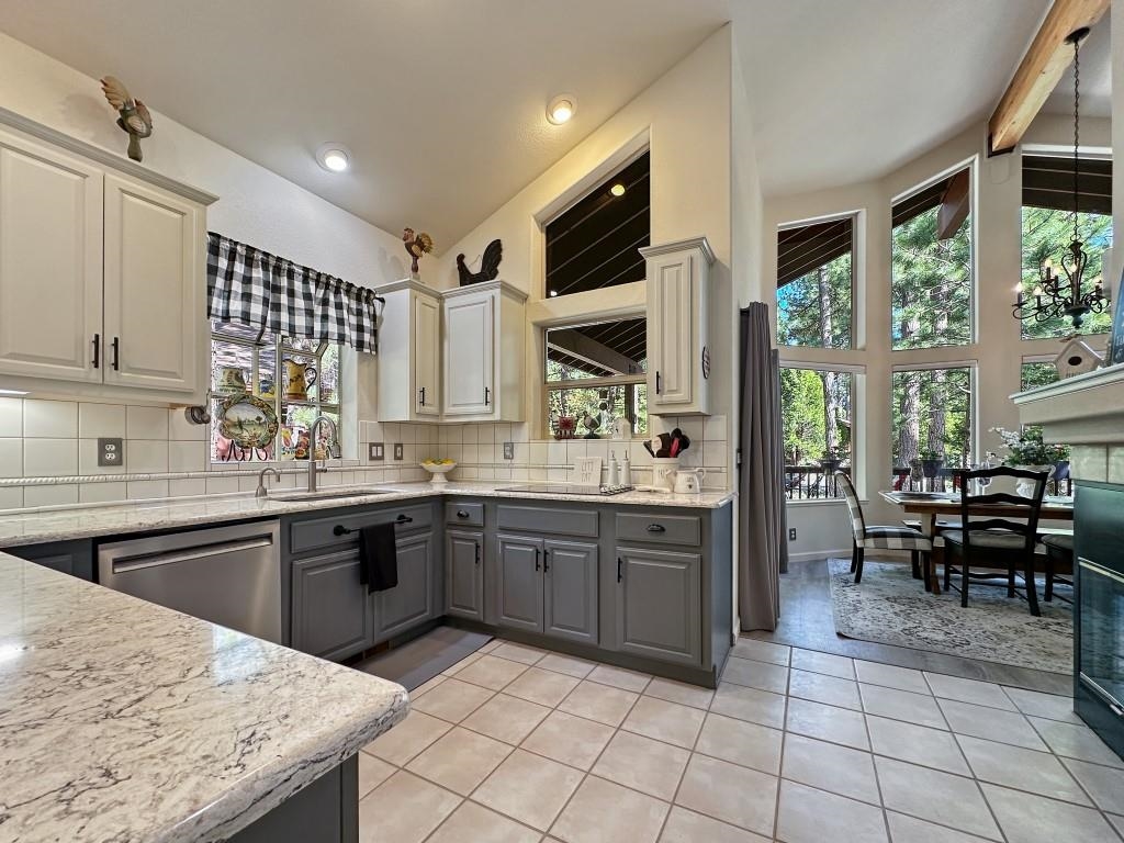 27 One Horse Way Clio, CA 96106 - Photo 9 of 38 a kitchen with stainless steel appliances granite countertop a stove top oven a sink dishwasher and white cabinets next to a window