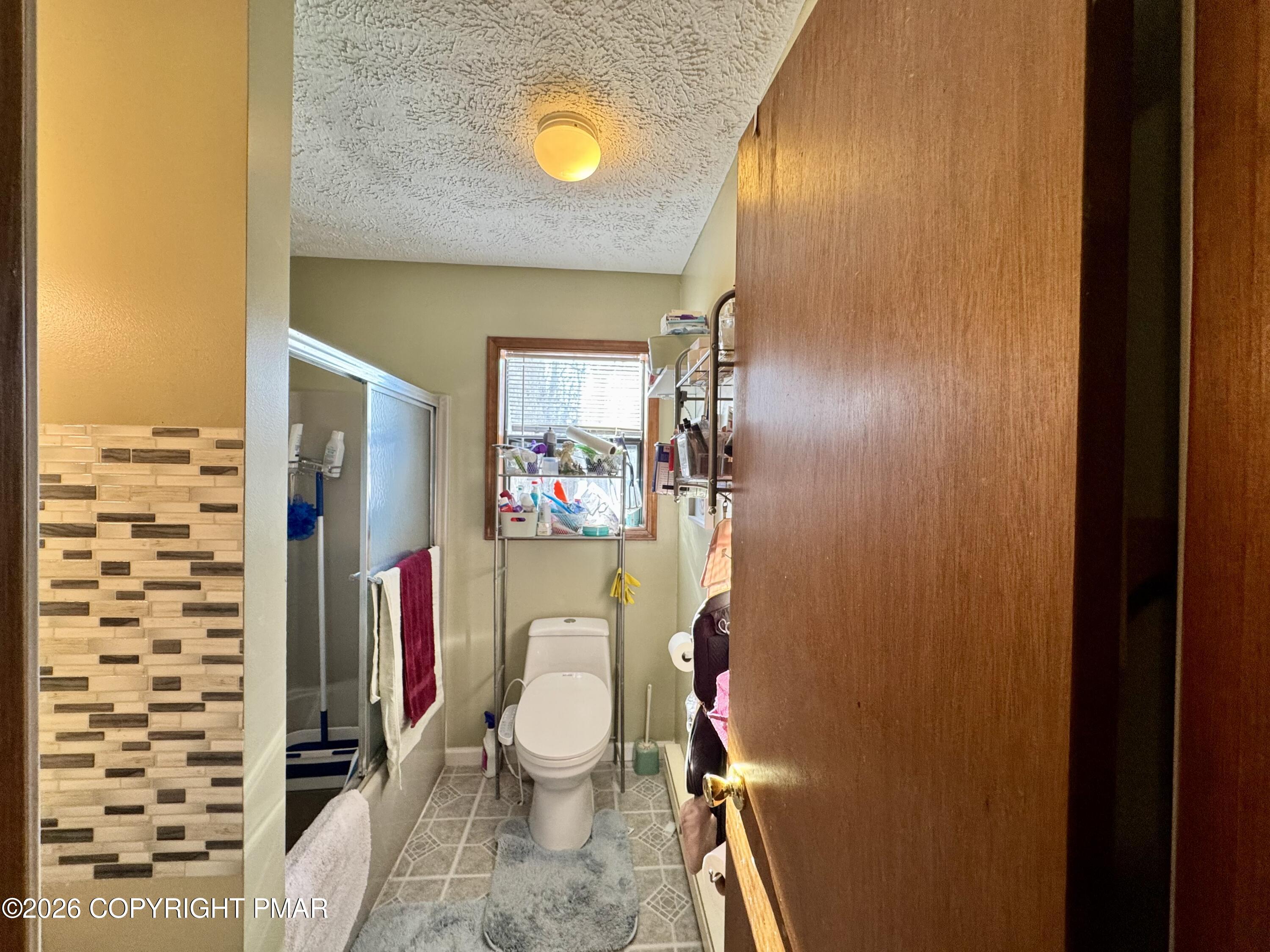 217 Bindale Road Tamiment, PA 18371 - Photo 13 of 27 a bathroom with a toilet and a shower curtain