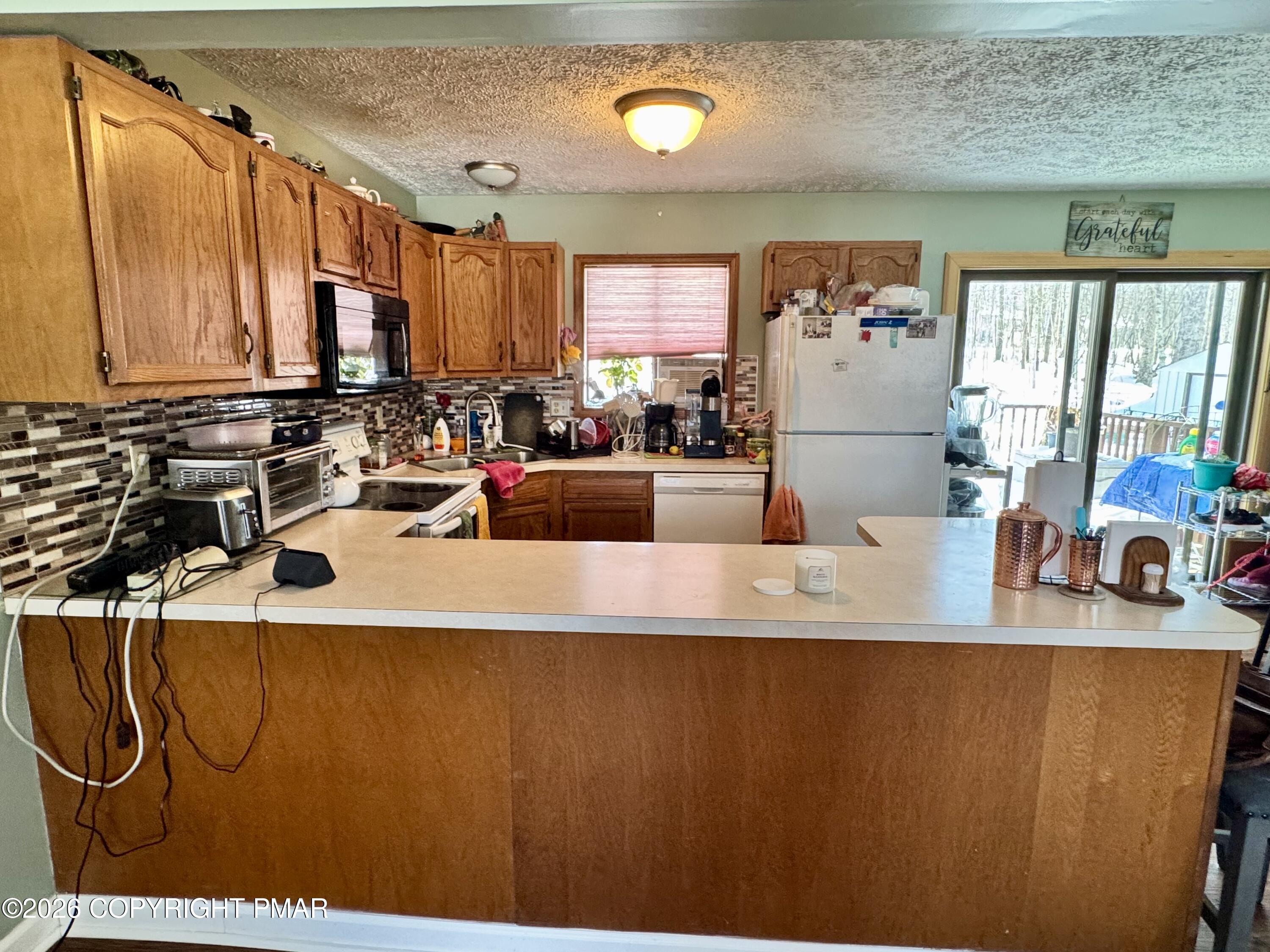 217 Bindale Road Tamiment, PA 18371 - Photo 7 of 27 a view of a kitchen with kitchen island a counter top space a sink a window and a couch