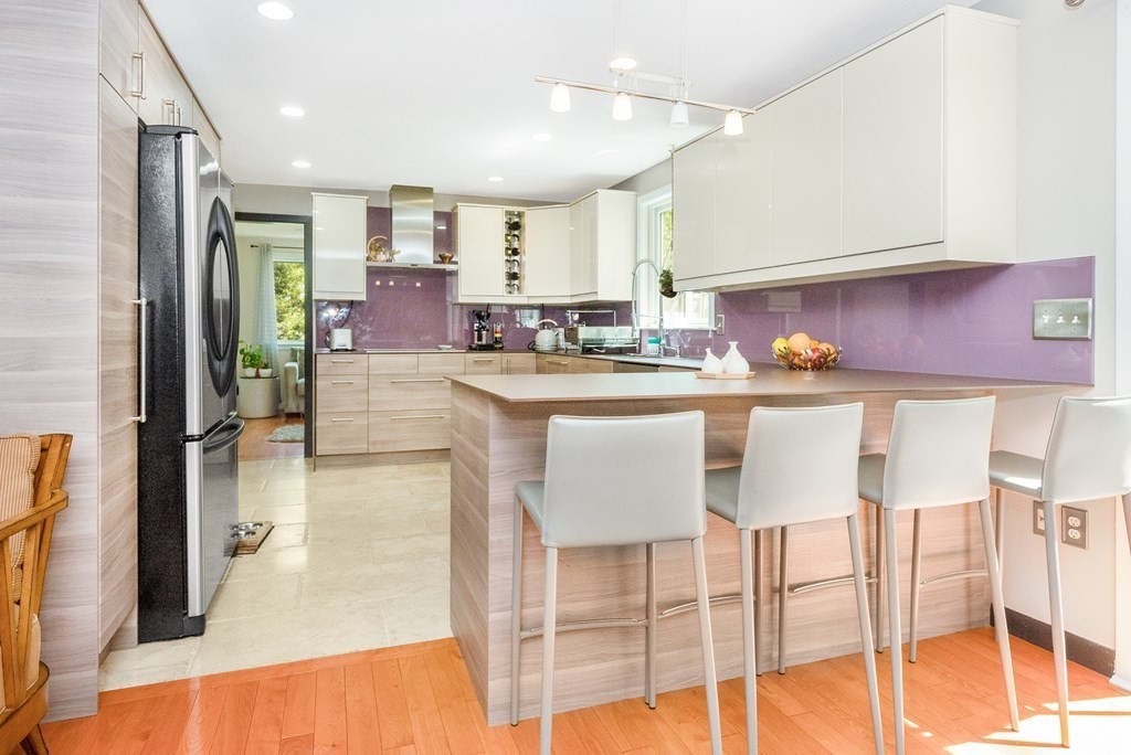 37 River Ridge Wellesley, MA 02481 - Photo 13 of 33 a kitchen with kitchen island granite countertop a table chairs refrigerator and microwave