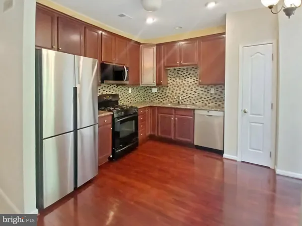 a kitchen with stainless steel appliances granite countertop a refrigerator stove top oven and sink