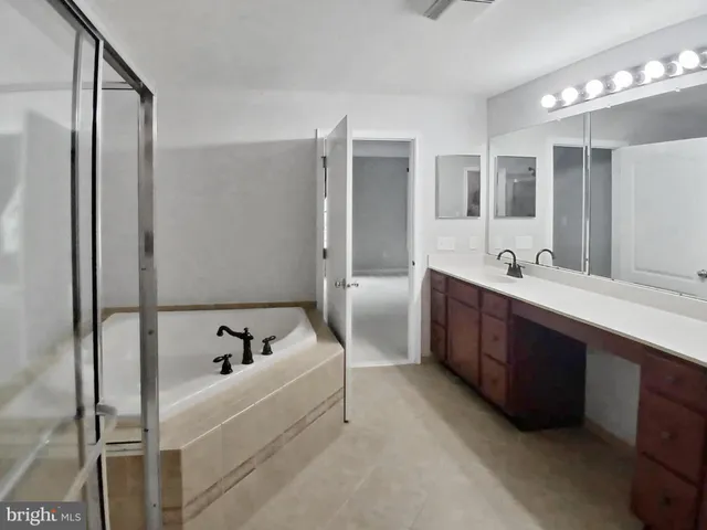a bathroom with a tub sink and mirror