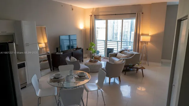a dining room with furniture a large window and a chandelier