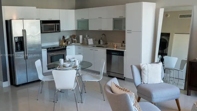 a kitchen with stainless steel appliances granite countertop a dining table and chairs